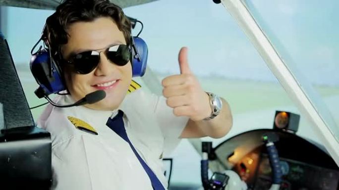 戴着墨镜的快乐男飞行员对着镜头微笑，竖起大拇指手势