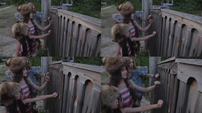 三个女孩穿着奇怪的皮草套装，敲开农村房屋的木门。