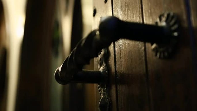 黑暗灯光下的古老锻铁门把手，古老豪宅的入口，秘密