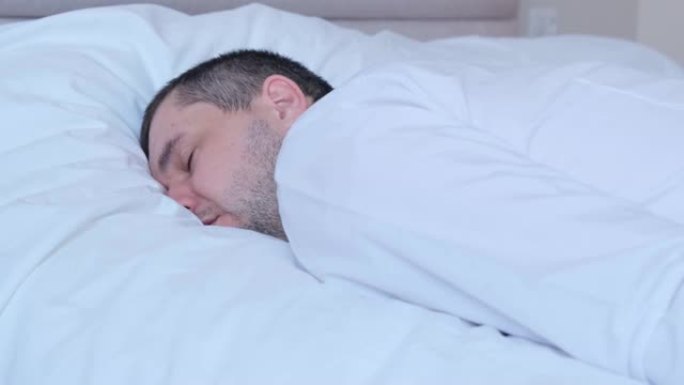 疲倦劳累的年轻人穿着衬衫睡在床上。