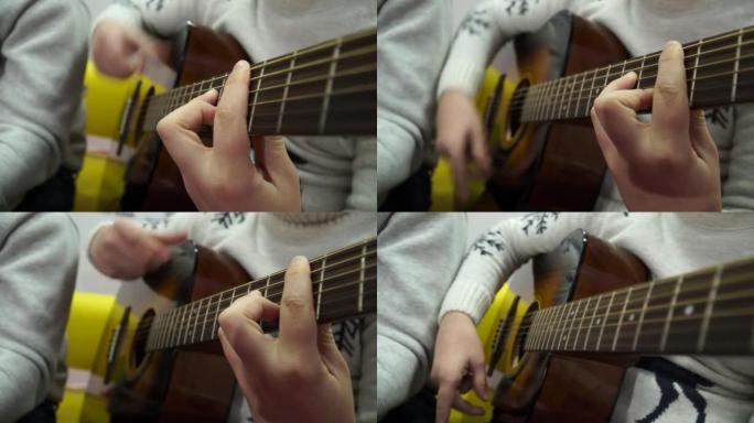 男孩开始弹原声吉他。原声吉他演奏的特写视频