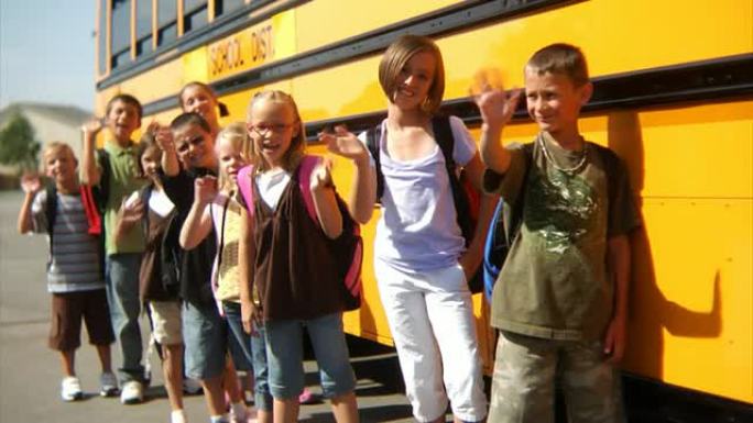 孩子们站在校车前挥手