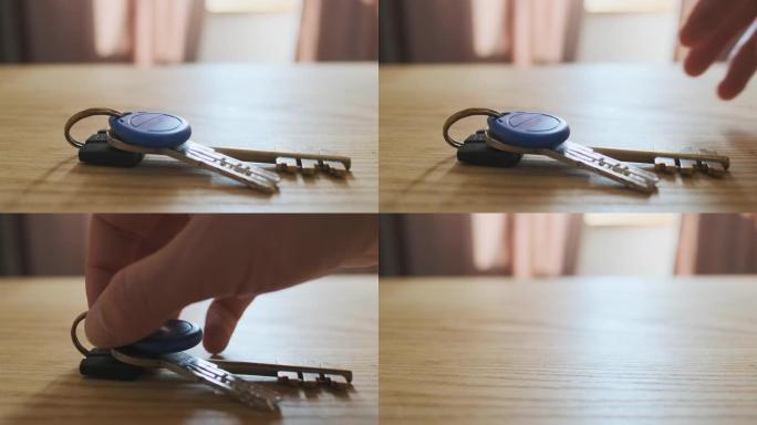 手从桌子上拿走公寓的钥匙。特写。家庭安全、公寓保护、日常生活、健忘的概念