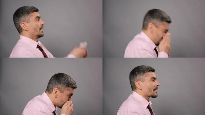 过敏，鼻炎，疾病。患病男性打喷嚏并用组织擦拭鼻子