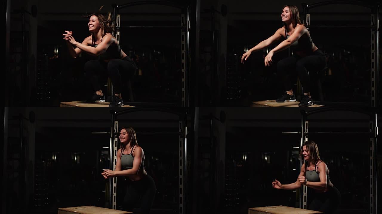 美丽的女性健身运动员表演盒子跳在一个黑暗的健身房穿着黑色运动上衣和短袜与脸部隐藏