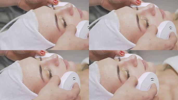 美容师在美容院中使用红外设备进行面部护理
