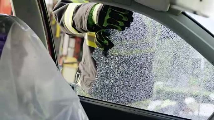 SLO MO消防员突破破碎的窗户到达驾驶员