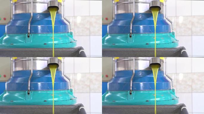 从旋转机的水龙头中倒入橄榄油，在工厂生产首次冷压橄榄油的过程