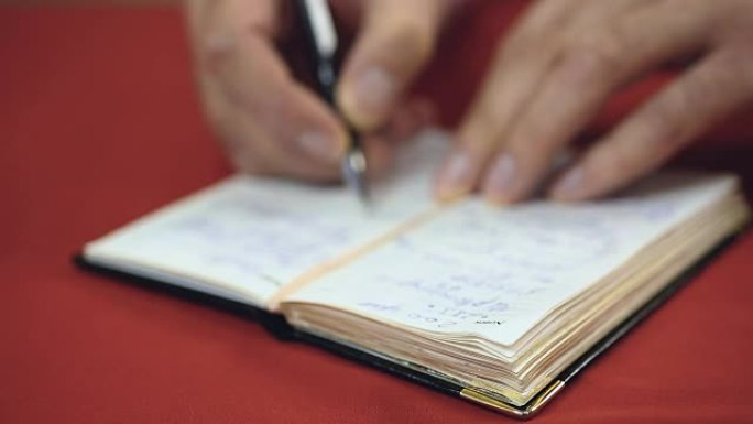商人在检查他的手写待办事项清单，制作新的笔记和提醒