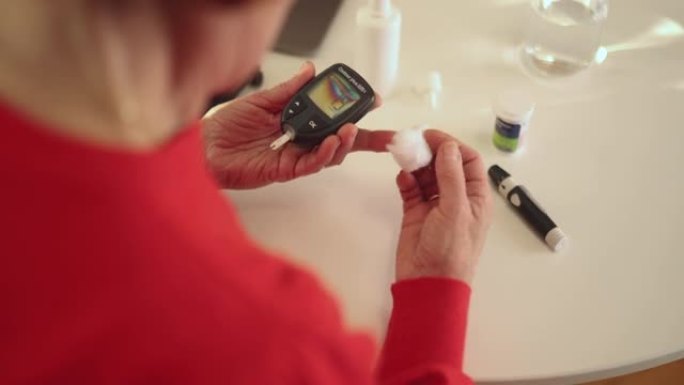糖尿病老年妇女用血糖仪检查血糖水平