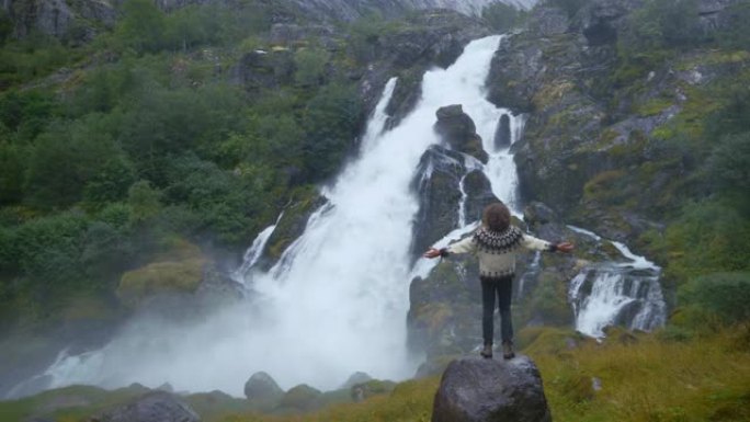 站在挪威山区瀑布附近的人