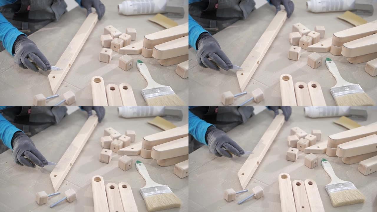 工人使用刮刀工具在木制品上手动涂抹油灰。手工木制品改进。