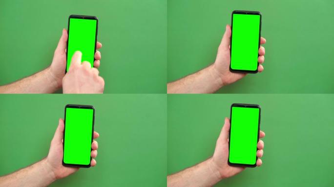 年轻人的手在绿色背景上使用带有绿色屏幕的智能手机。手势包。男性手触摸，点击，点击在黑色手机chrom