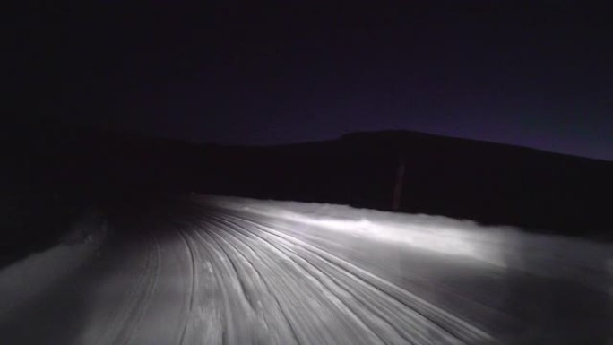 晚上在森林的雪路上开车。