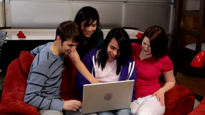 一群年轻人一起看笔记本电脑