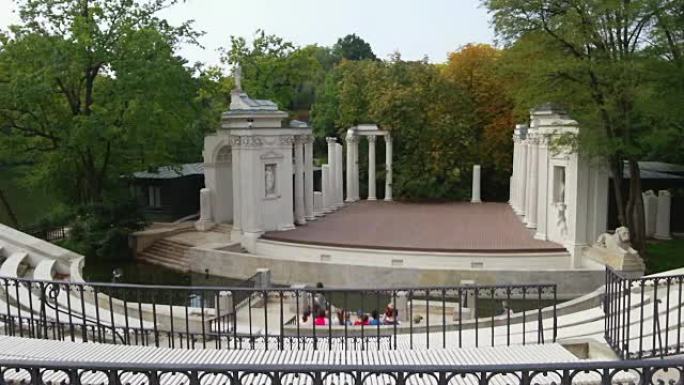 华沙拉齐恩基公园的旧圆形剧场。一群游客坐着