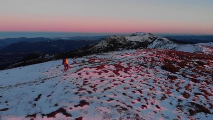 鸟瞰图的男性徒步旅行者上升通过冬天的雪在山上