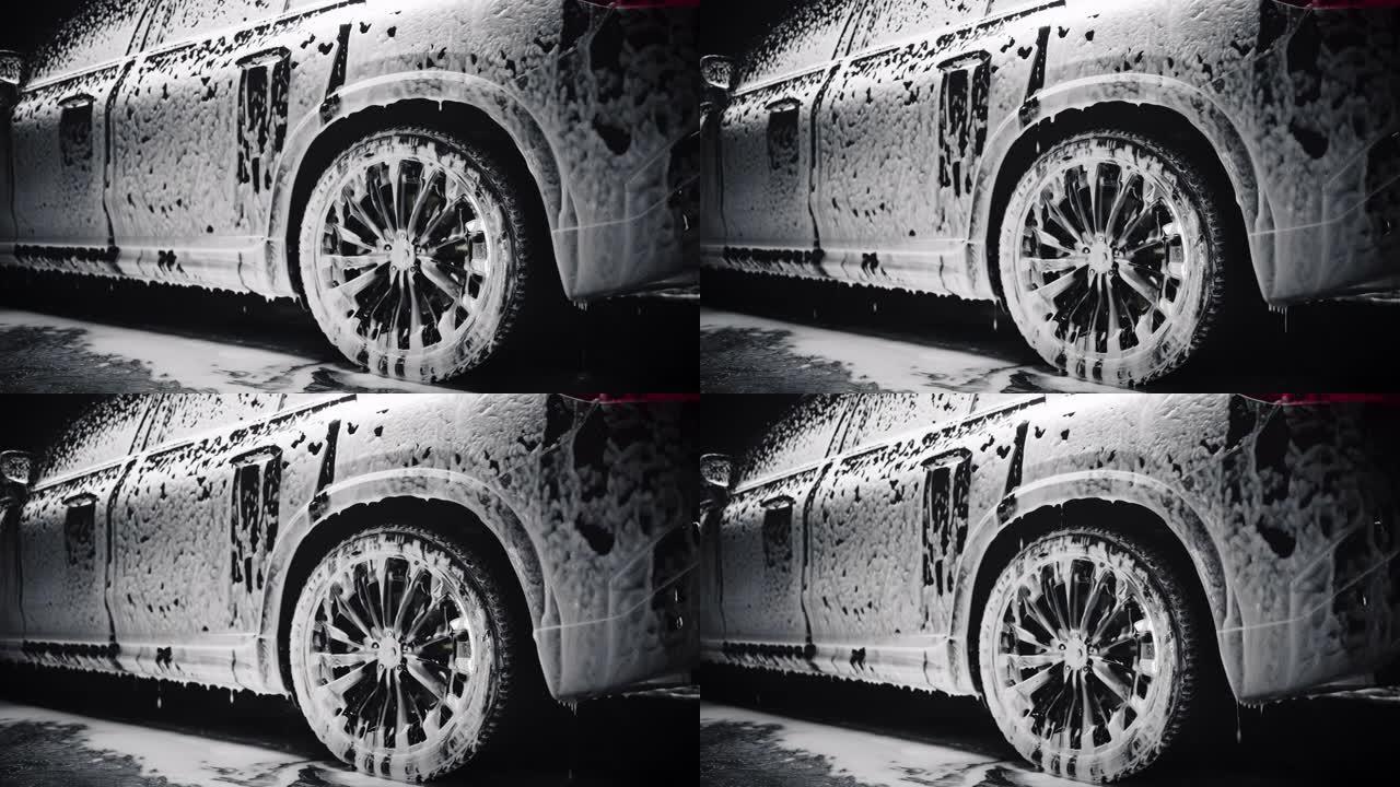 Cinematic Studio用一辆环保电动家用SUV站在洗车处来拍摄镜头。车辆被泡沫覆盖，在出售