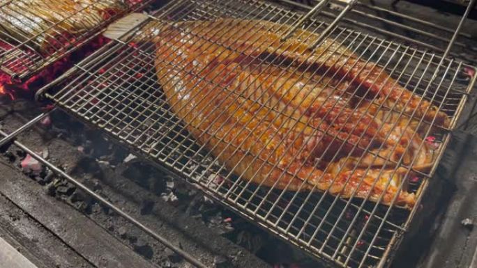 烧烤用明火烧烤珊瑚鱼牛排，用燃烧的木炭烤架抽烟。假日之夜烹饪食物特写。鱼烧烤报价