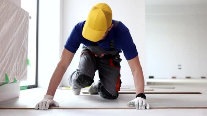 工人铺设乙烯基或强化地板翻新家庭或办公室