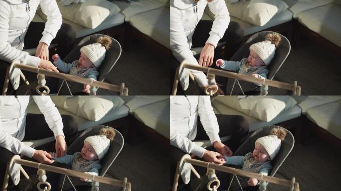 一个年幼的婴儿在母亲照顾的椅子上大惊小怪的特写镜头