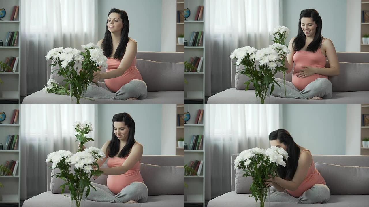 可爱的怀孕女孩用漂亮的花装饰房子，审美享受