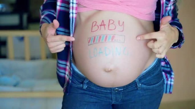 蓝色和粉红色的婴儿在女人的怀孕肚子上加载铭文，期待妈妈等待她的婴儿到来，快乐的女性轻轻地抚摸她的怀孕