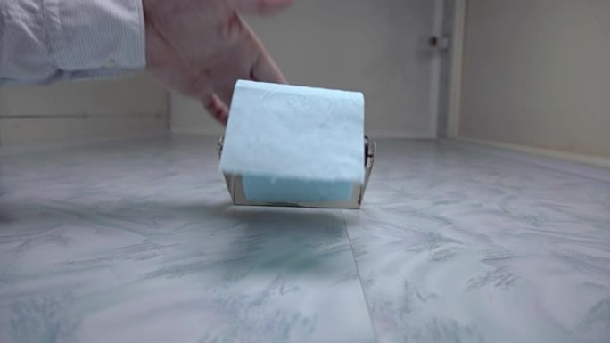 手解开一卷卫生纸，撕掉一块所需的