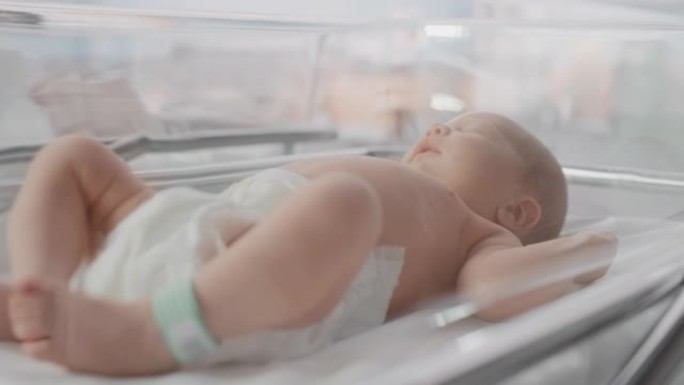 婴儿出生后躺在产科病房摇篮中的婴儿肖像。可爱的新生儿呼唤母亲，感到精力充沛，失眠。分娩和医疗诊所的概