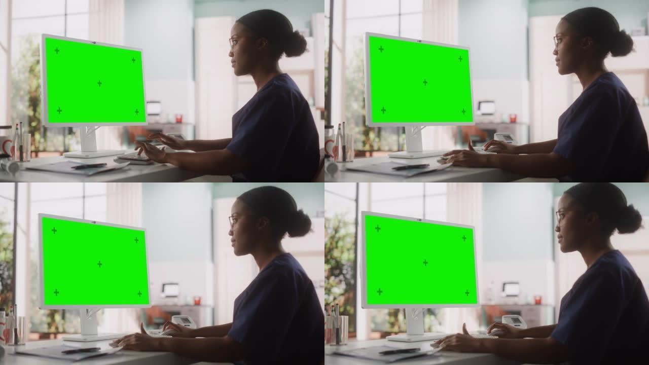 一位美丽的黑人女性医疗保健专业人员在医院绿屏色度键显示的电脑上工作的肖像。诊所护士长正在更新电子健康