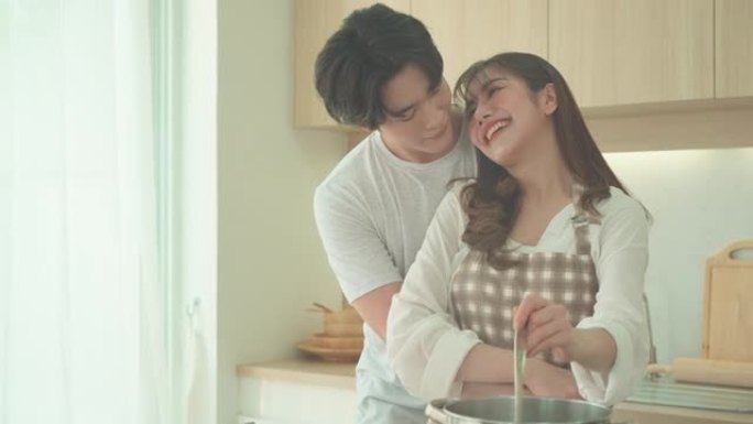 亚洲夫妇正在家里的厨房里帮忙做鸡汤。一对情侣的浪漫场景