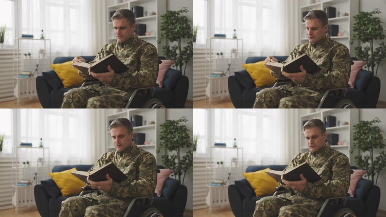 专注的男子轮椅使用者在军装阅读圣经，天主教徒