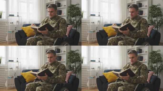 专注的男子轮椅使用者在军装阅读圣经，天主教徒