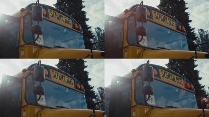 带有警告标志的前视图学术巴士车窗黄色红色前灯关闭。