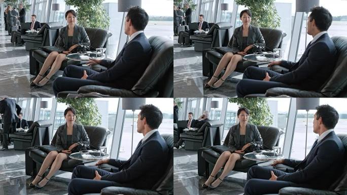 DS亚洲商人男女坐在机场的商务休息室里聊天