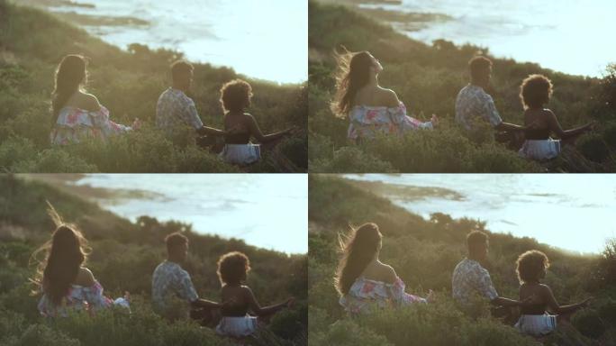 一群不同的朋友坐在海边的草崖上，一起放松。在莲花位置冥想