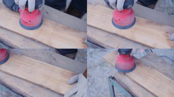从上方观看。砂光机沿着木板移动，对其进行抛光。木匠的手握着电动研磨机，一边打磨木板。木匠的概念是磨板