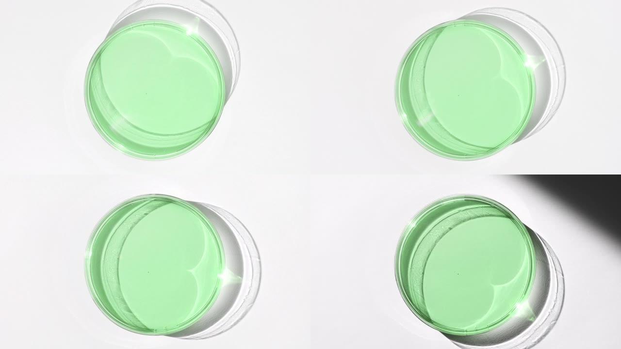 玻璃上的绿色眼睛凝胶被白色背景上的阴影覆盖