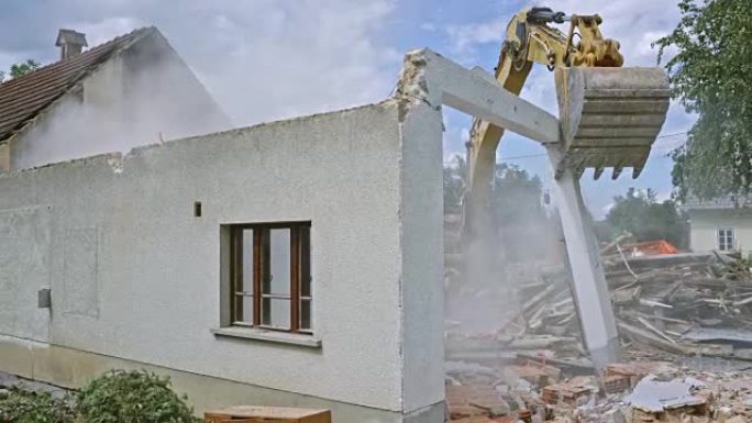 挖掘机推动建筑物的最后剩余墙壁并拆除它们