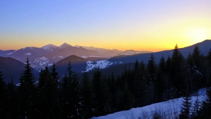 山地冬季景观中五彩缤纷的日落。晴朗的蓝天没有云。