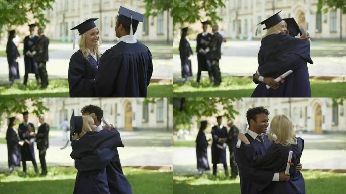 研究生在学术服装拥抱和旋转，大学友谊