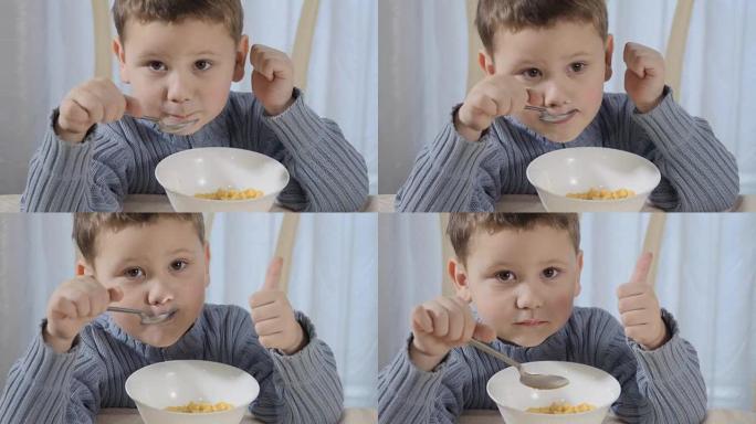 可爱的小男孩吃玉米片露出拇指