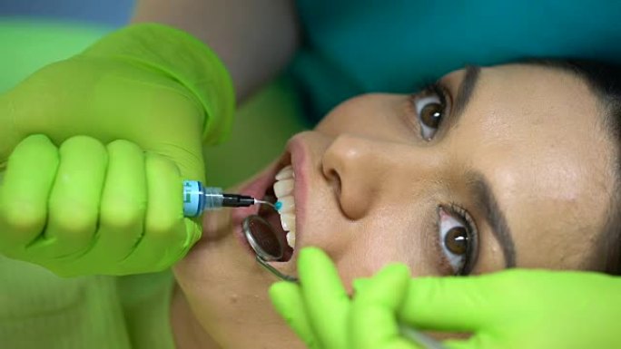 牙医在牙齿上使用蓝色凝胶，造型膏，美容牙科，特写