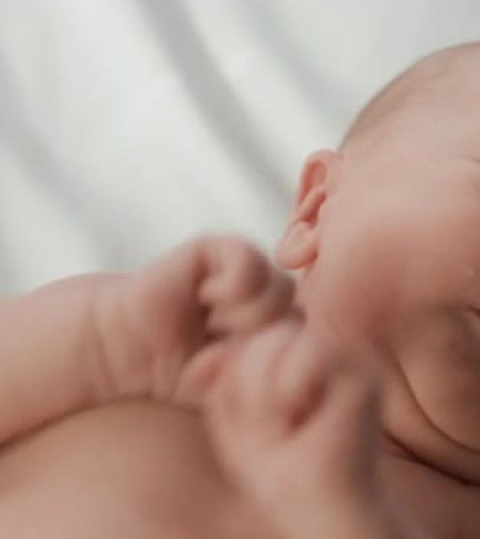 垂直屏幕: 婴儿出生后躺在产科病房摇篮中的婴儿的肖像。可爱的新生儿呼唤妈妈，感觉精力充沛，失眠