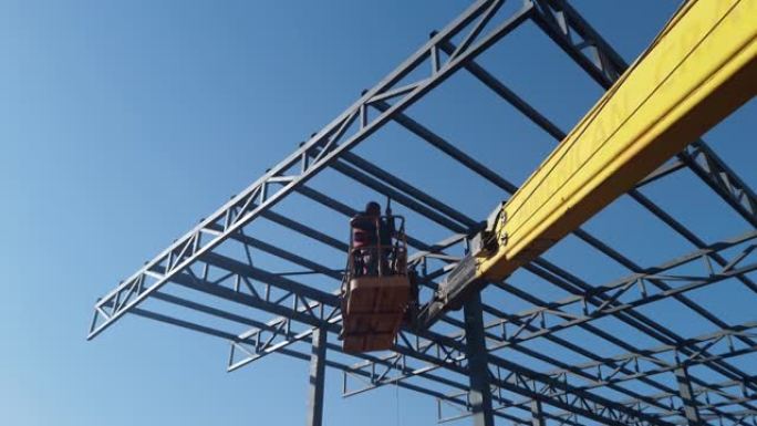 高空作业平台上的工人建造大型建筑物屋顶的金属结构