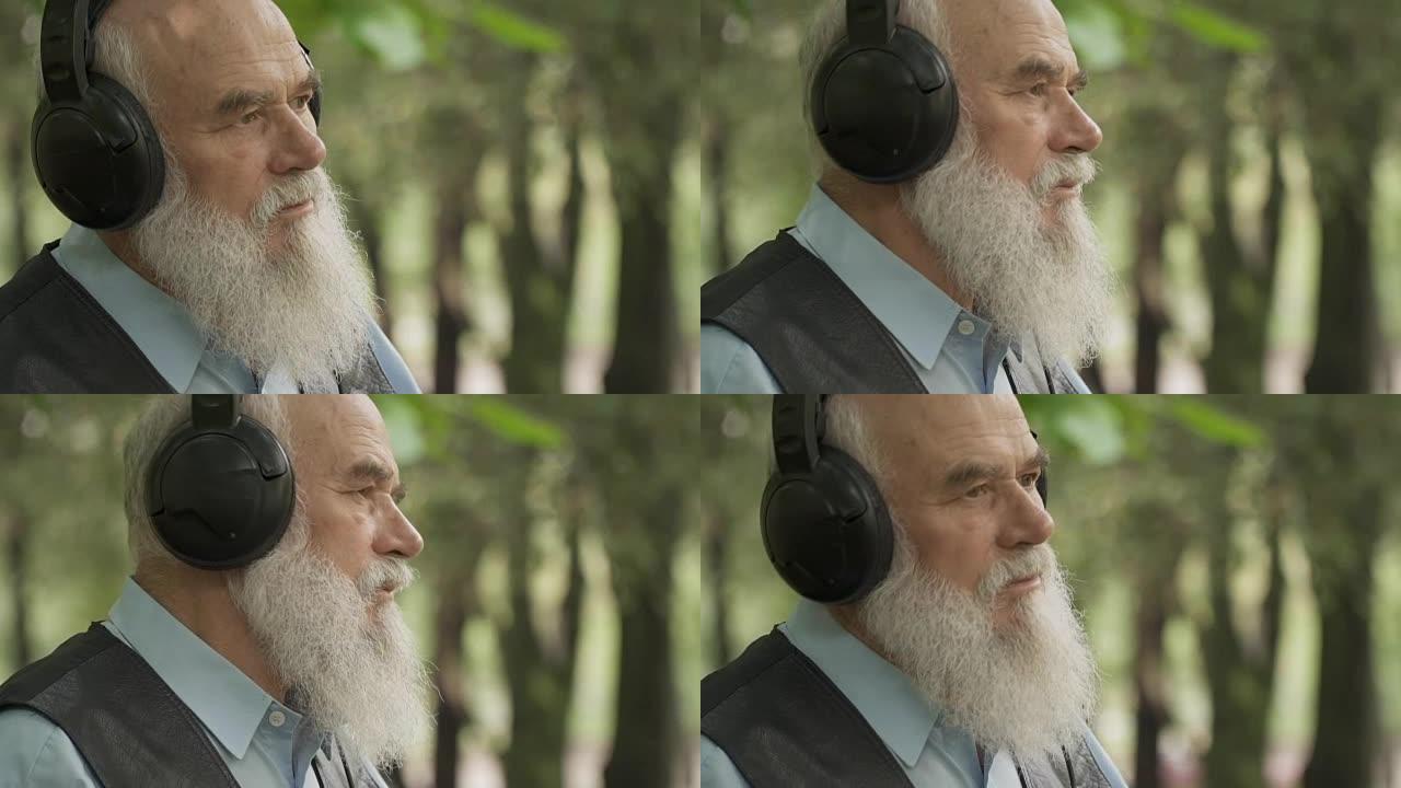 灰发老人戴着耳机听音乐