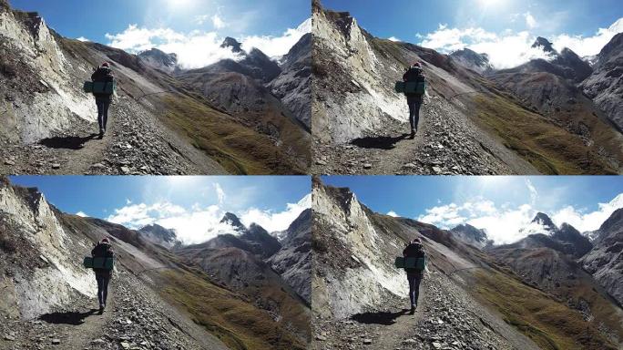 女徒步旅行者登上山谷上方的山路