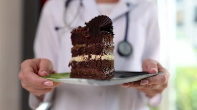 营养学家拿着甜巧克力蛋糕，并警告糖果的危险