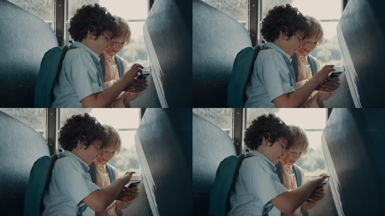 两个学生在坐校车的电话上玩游戏。男孩们使用智能手机。