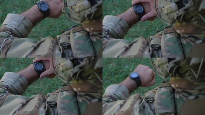 特写，难以辨认的男性士兵迷彩制服，准备军事演习或战斗。详细拍摄的军人检查时间，看手表。乌俄战争